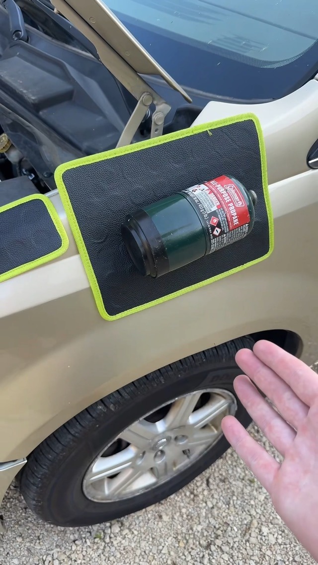 Tapete magnético na lataria de um carro, segurando um pequeno cilindro metálico